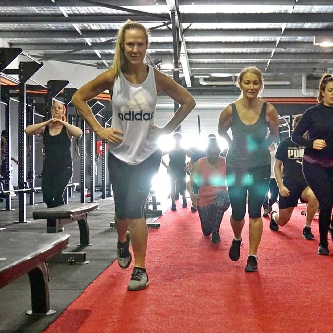 LX members doing walking lunges together on the gym floor